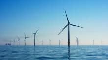A photograph of several wind turbines, standing in the ocean. Image by Nicholas Doherty.